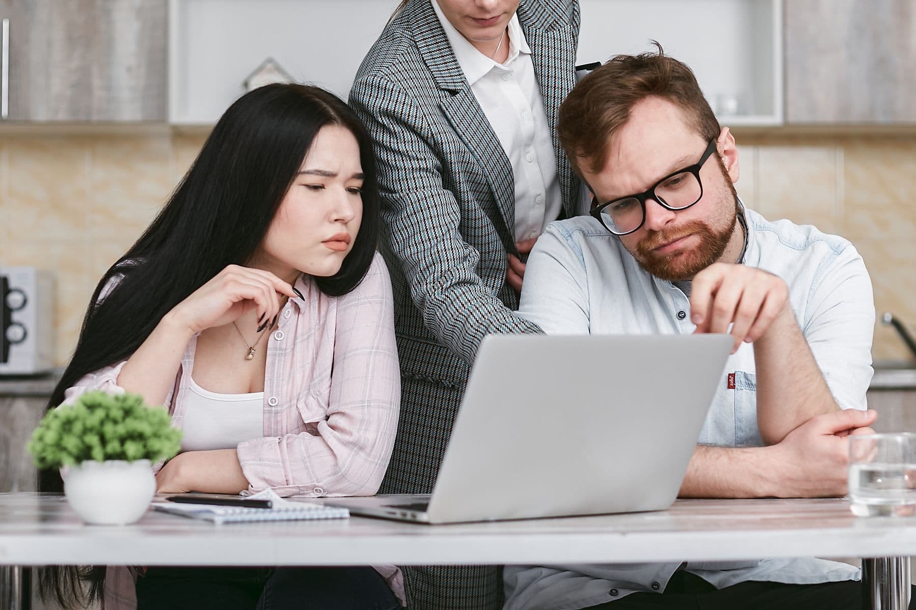 Een productprofessional die analytics gebruikt op een laptop in een moderne werkplek
