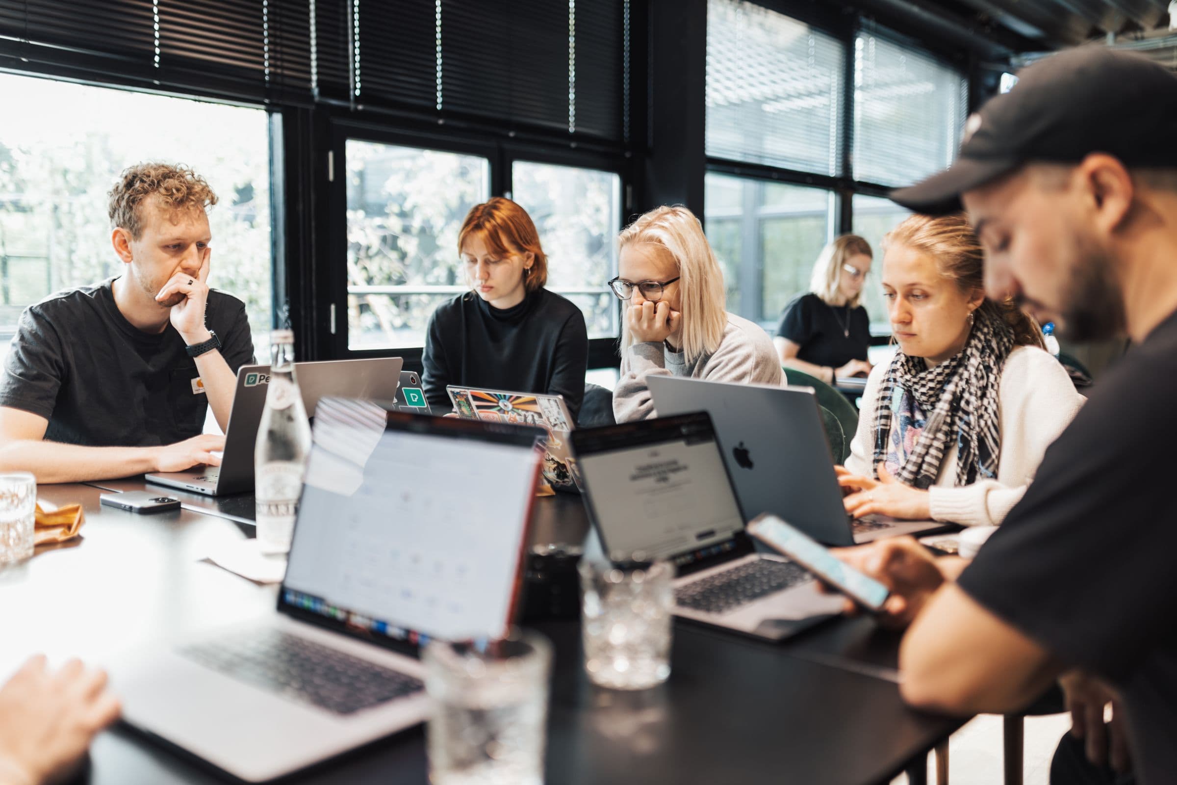 A product team collaborating on laptops in a modern office.